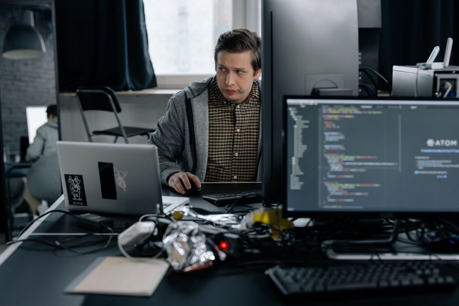 Programer u modernom uredu radi na kodu, prikazuje fokusirano radno okruženje